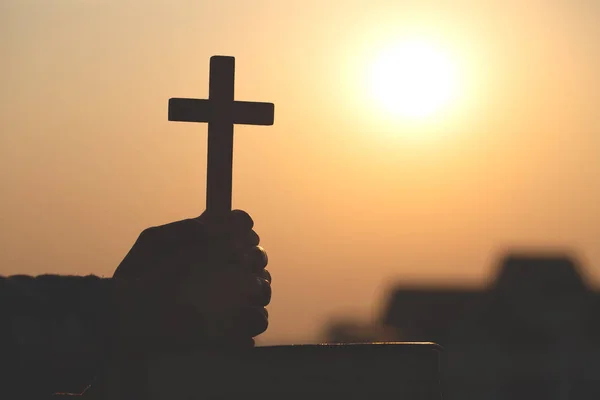 Silhouette de jeune femme priant avec des croix et des bibles au soleil — Photo