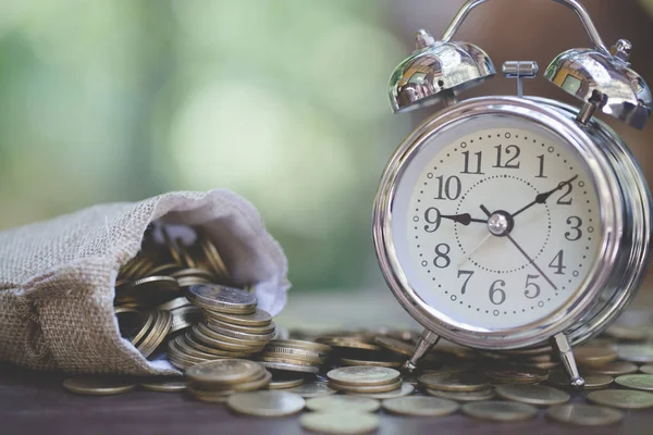 Money bags and  clock on wooden table with nature background,  M — Stock Photo, Image