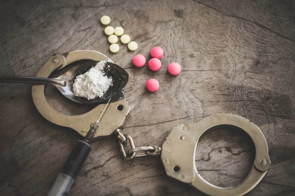 Drug syringe and cooked heroin on spoon and handcuffs . Concept — Stock Photo, Image