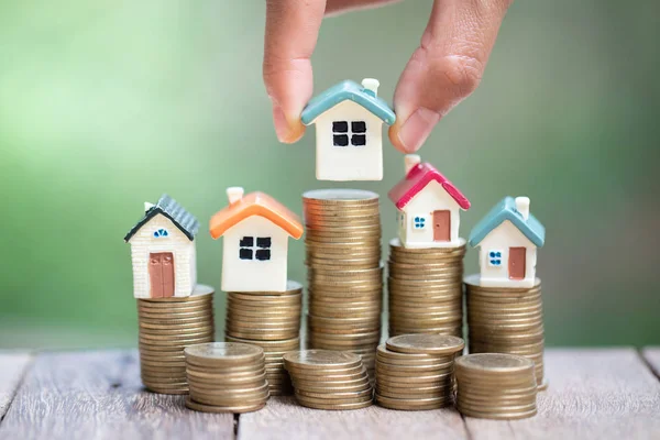 Inversor mostrar la mano sosteniendo una casa modelo y moneda, Ahorro de dinero — Foto de Stock