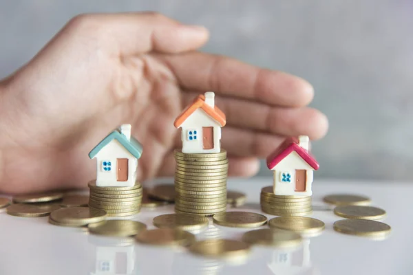 Handen als een beschermende dak over een klein huis, onroerend goed insuran — Stockfoto