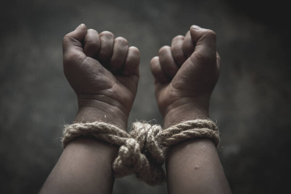 Victim boy with hands tied up with rope in emotional stress and 