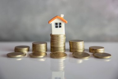 Madeni para yığını üzerinde mini ev. Yatırım mülkiyet kavramı ve