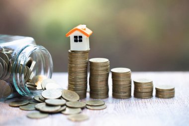 Madeni para yığını üzerinde mini ev. Yatırım mülkiyet kavramı ve