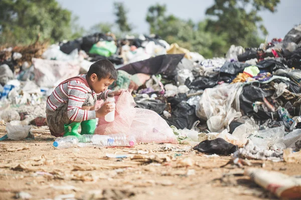 Pobre chico recogiendo basura en su saco para ganarse la vida , — Foto de Stock