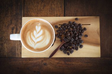 eski ahşap arka planda kahve bardağı ve kahve çekirdekleri, üst görünüm