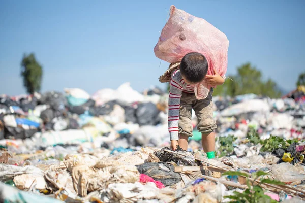 Pobre chico recogiendo basura en su saco para ganarse la vida , — Foto de Stock