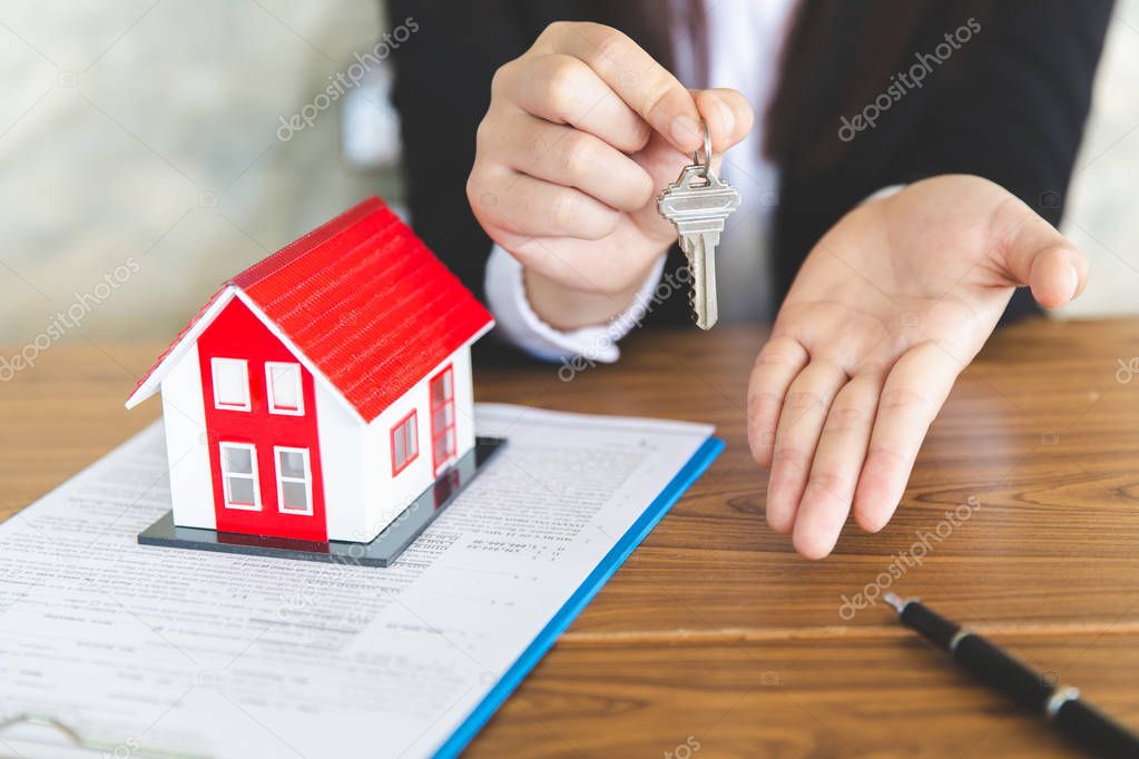 Your new house, real estate agent holding house key to his clien