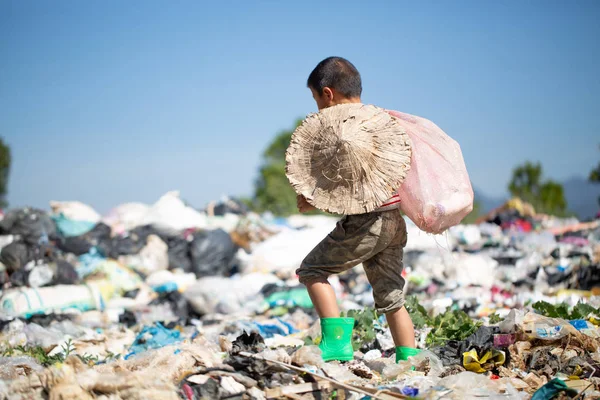 Pobre chico recogiendo basura en su saco para ganarse la vida , — Foto de Stock