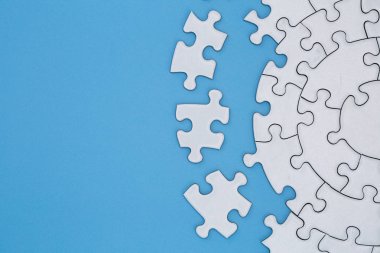 Mavi arka planda tamamlanmamış beyaz puzzle parçaları, La
