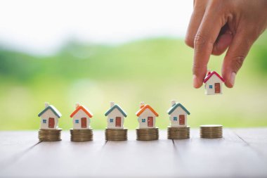 Ev modeli sikke yığını üzerinde koyarak kadın eli. Pro için kavramı