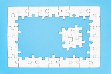 Mavi arka planda tamamlanmamış beyaz puzzle parçaları, La