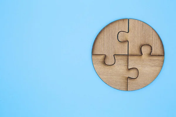 Wooden jigsaw puzzle on a blue background