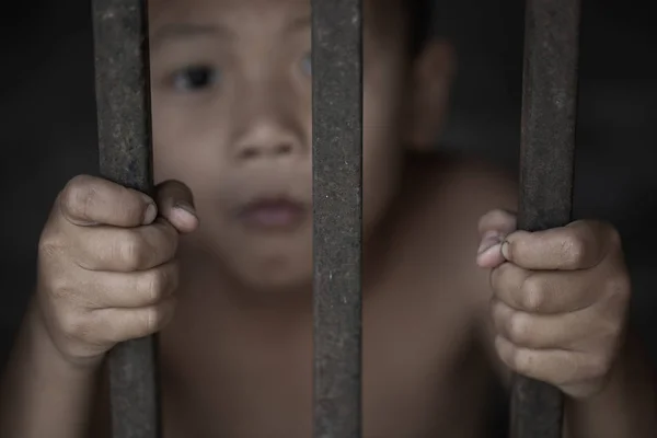 El niño capturó la jaula de hierro con tristeza y desesperación. La c — Foto de Stock