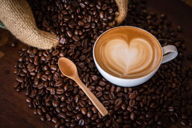 Kahveli latte, kahve çekirdekleri koyu arka planda, manzaralı.