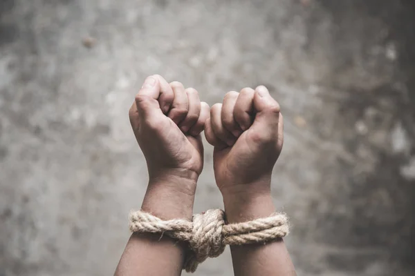 Gewalt und Missbrauch von Kindern, der Junge wird an der Hand mit einem Seil gefesselt. — Stockfoto