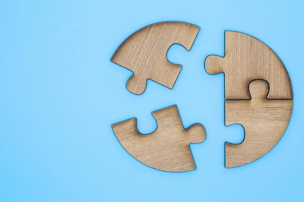 Wooden jigsaw puzzle on a blue background.  Wooden jigsaw puzzl