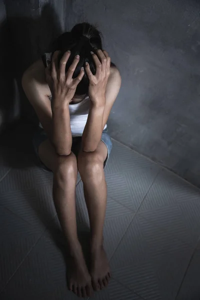 Giovane donna spaventata seduta nell'angolo della sua camera da letto, disperazione — Foto Stock