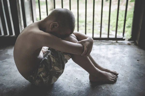 Barn krama hennes knä på golvet, medan sittande ensam i bur var im — Stockfoto