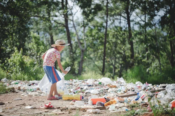 Un pobre chico recogiendo basura de un vertedero en el — Foto de Stock