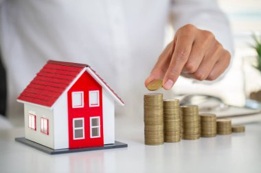 Ev modeli sikke yığını üzerinde koyarak kadın eli. Pro için kavramı