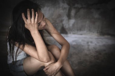 Depresyonda olan kadın odanın bir köşesinde oturuyor ve tacizden, aile içi şiddetten, şiddetten, dövülmekten ve tecavüze uğramaktan korkuyor..