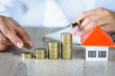 Mülk yatırımı ve ev kredisi finansal konsepti, El para destesini model eve koyuyor..