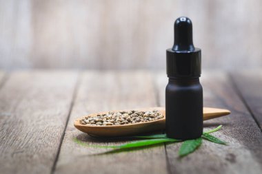 Tahta kaşıkta kenevir yağı ve kenevir tohumu içeren cam şişeler, araştırmacıların ya da tıbbi ekibin çıkardığı CBD kenevir yağı. Bitkisel alternatif tıp.