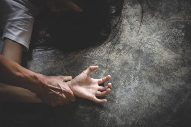 Tecavüz ve cinsel istismar konsepti için bir kadının elini tutan erkek elini yakın tut. Kadınlara şiddet.