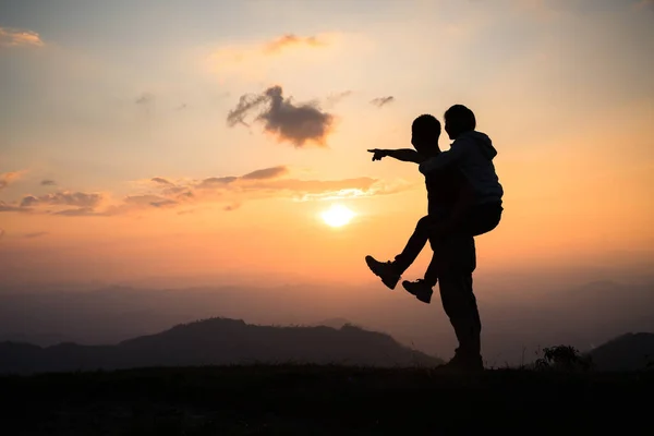 Couple on the mountain, Silhouette of happy couple  having fun over mountains backgroun