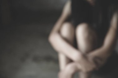  Karanlık odada oturan genç kadınların bulanık görüntüsü. Hayat sıkıntısı çeken acılar hissediyorlar. Şiddete son verin, şiddete son verin, kadınlara, aile içi şiddete, insan kaçakçılığına..