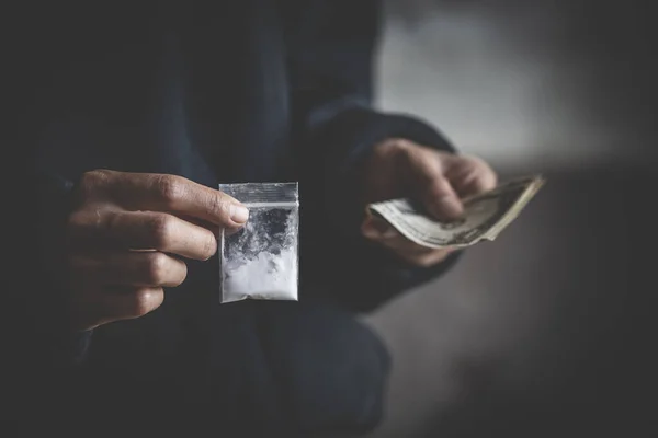close up of addict with money buying dose, Purchase, possession and sale of drugs is punishable by law. drug trafficking,  addiction and sale concept.