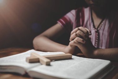 Dindar Hıristiyan çocuk içeride İncil için dua ediyor.
