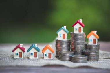Bozuk para yığınında model ev. Ev satın alma, ipotek ve gayrimenkul yatırımı için para biriktirme.