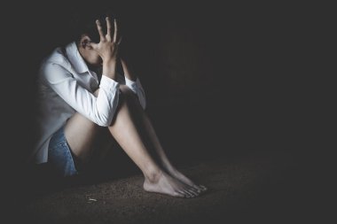 Depresyonda olan genç bir kadın, aile içi şiddet ve tecavüz, dövülmüş ve tecavüze uğramış, köşede oturmuş, boşluğu kopyalıyor. Uluslararası Kadınlar Günü