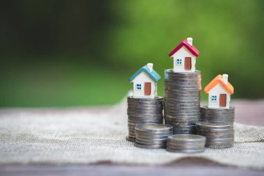 Bozuk para, ev, ipotek, ev almak için biriktirilen para ve emlak konseptine yatırılan kredilerin olduğu küçük bir ev. Girişim ve Risk Yönetimi, izole.