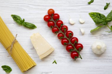 Spagetti ve makarna üzerine beyaz ahşap zemin, yukarıdan yemek pişirmek için farklı malzemeler. Düz yatıyordu. Üstten Görünüm.