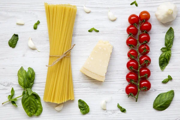 Makarna arka plan. Makarna bir beyaz tahta masada yemek pişirmek için malzemeler. Düz yatıyordu. Yukarıdan. Üstten Görünüm.