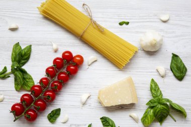 Beyaz ahşap zemin, üstten görünüm üzerinde İtalyan makarna yemek pişirmek için maddeler kümesi. Düz yatıyordu.