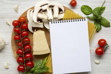 Yuvarlak ahşap tahta malzemelerle makarna ve dizüstü Beyaz ahşap zemin üzerinde yemek pişirmek için. Üstten Görünüm. Düz yatıyordu. Yukarıdan. Kopya alanı.