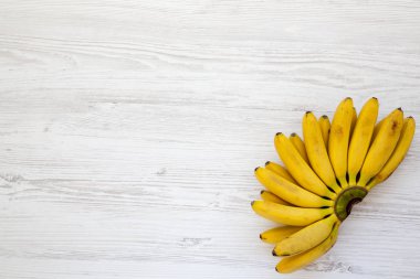 Bebek Muz Beyaz ahşap arka plan, üstten görünüm üzerinde bir grup. Metin için yer.