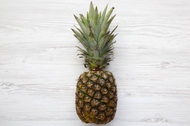 Beyaz ahşap zemin üzerinde olgunlaşmış ananas. Yukarıdan. Üstten görünüm.