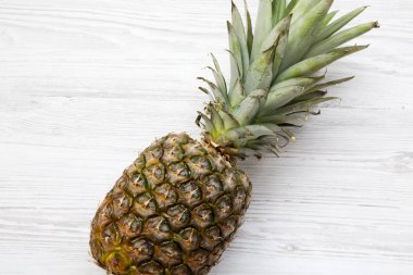 Beyaz ahşap zemin üzerinde olgunlaşmış ananas. Yukarıdan. Üstten görünüm.