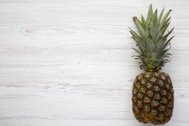 Beyaz ahşap zemin üzerinde olgunlaşmış ananas. Yukarıdan. Üstten görünüm. Kopya alanı.
