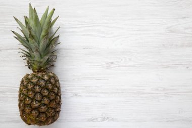 Beyaz ahşap zemin üzerinde olgunlaşmış ananas. Yukarıdan. Üstten görünüm. Kopya alanı.