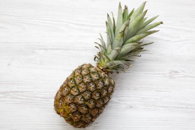 Beyaz ahşap zemin üzerinde büyük Olgun ananas. Yukarıdan. Üstten görünüm.
