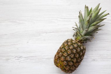 Büyük Olgun ananas kopya alanı ile beyaz ahşap zemin üzerinde. Yukarıdan. Üstten görünüm.