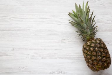Büyük Olgun ananas kopya alanı ile beyaz ahşap zemin üzerinde. Yukarıdan. Üstten görünüm.