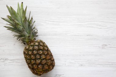 Büyük Olgun ananas kopya alanı ile beyaz ahşap zemin üzerinde. Yukarıdan. Üstten görünüm.