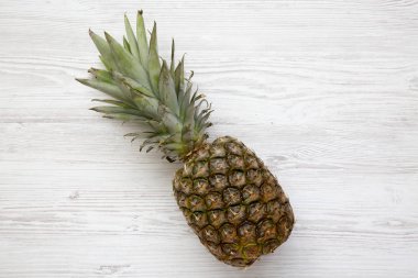 Büyük Olgun ananas kopya alanı ile beyaz ahşap zemin üzerinde. Yukarıdan. Üstten görünüm.